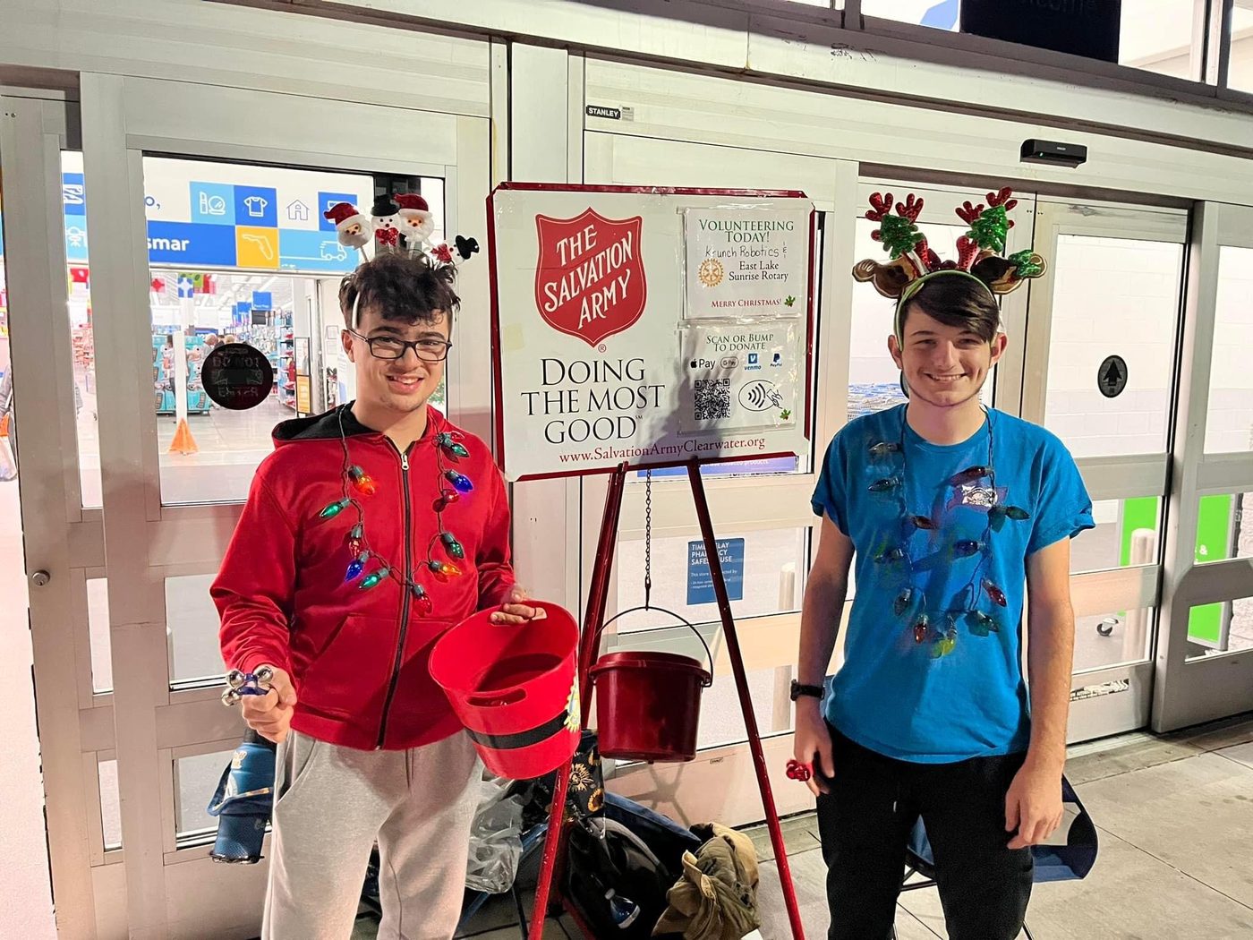 Team 79 Krunch students ringing the bell at a Salvation Army Red Kettle with the Rotary Club of East Lake Sunrise