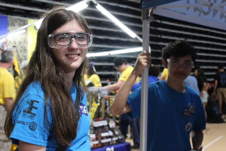 A Team 79 Krunch student in safety glasses smiling in the pit at the 2025 FIRST Robotics Competition